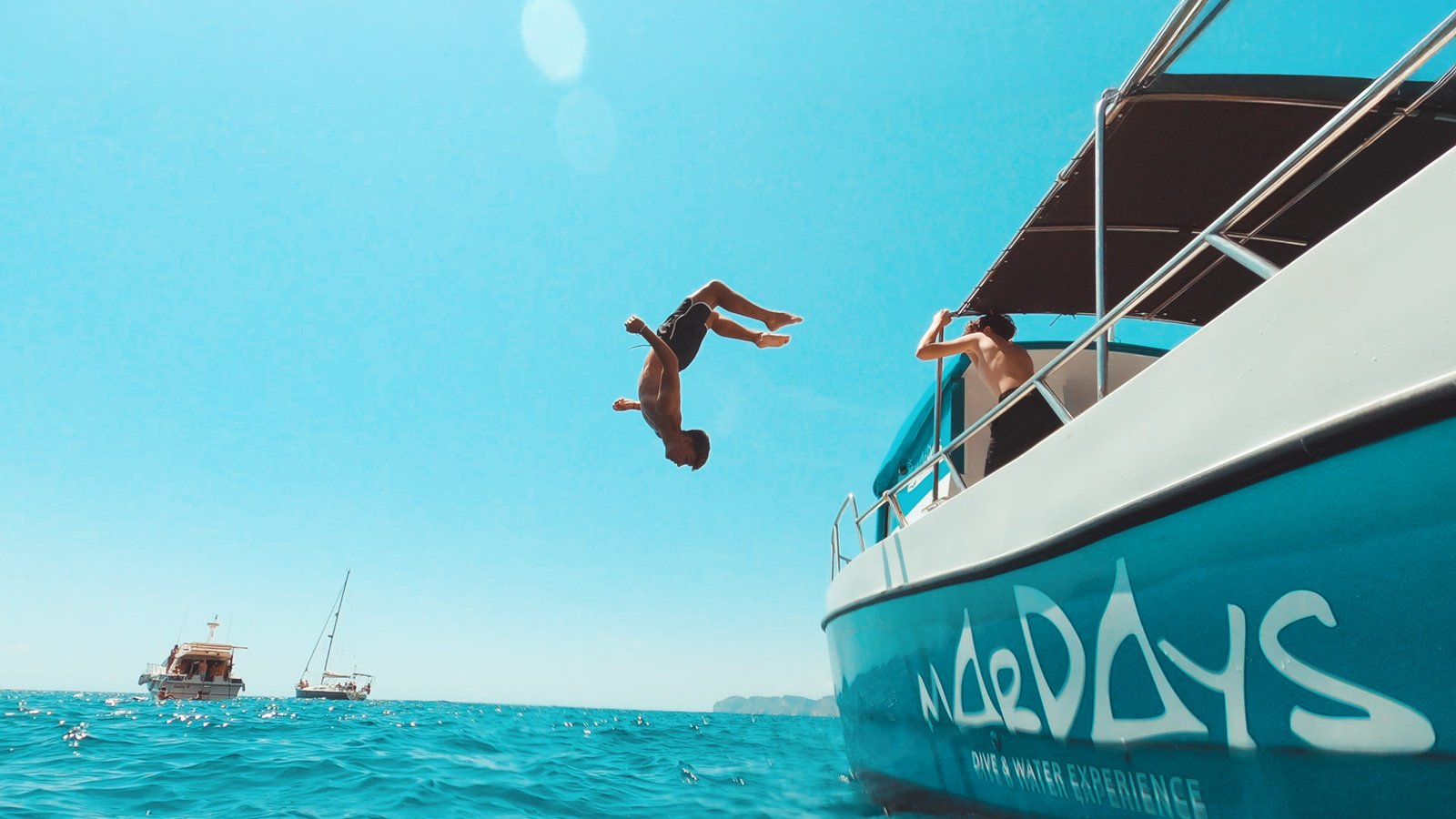 Acróbata haciendo backflip desde barco al mar en Indomove Academy