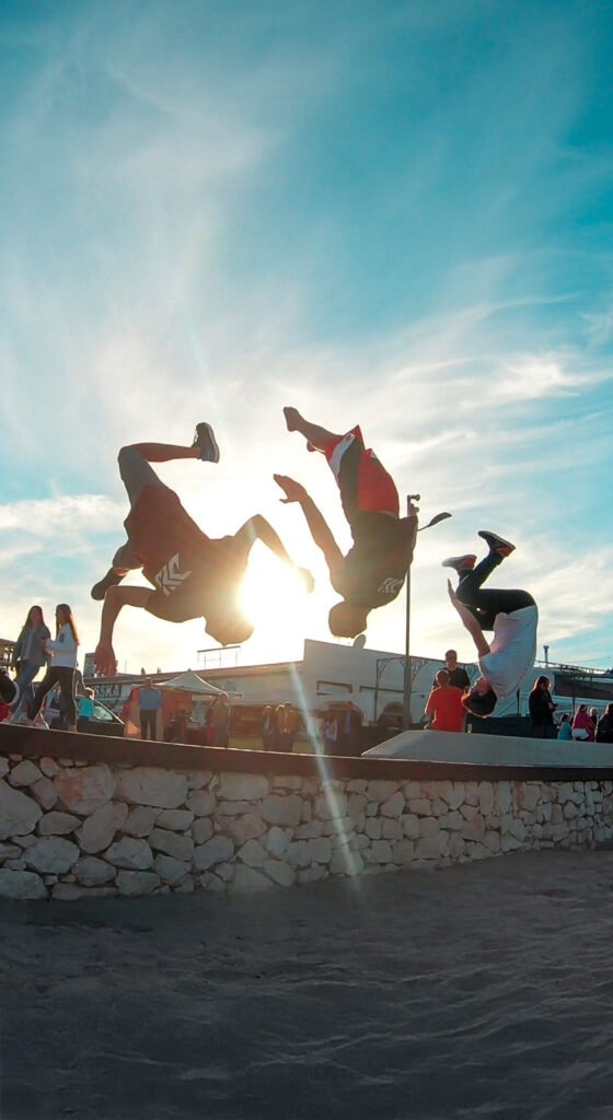 Gimnastas haciendo un backflip en la playa en Indomove Academy